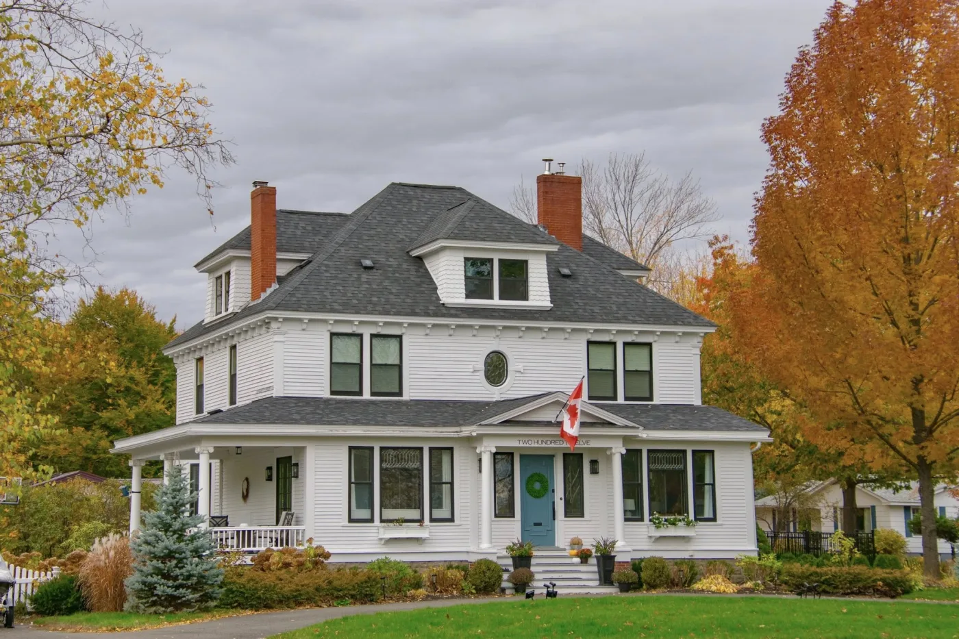 Large Fredericton-area home exterior in autumn, representative of mixed-age housing stock first-time buyers evaluate