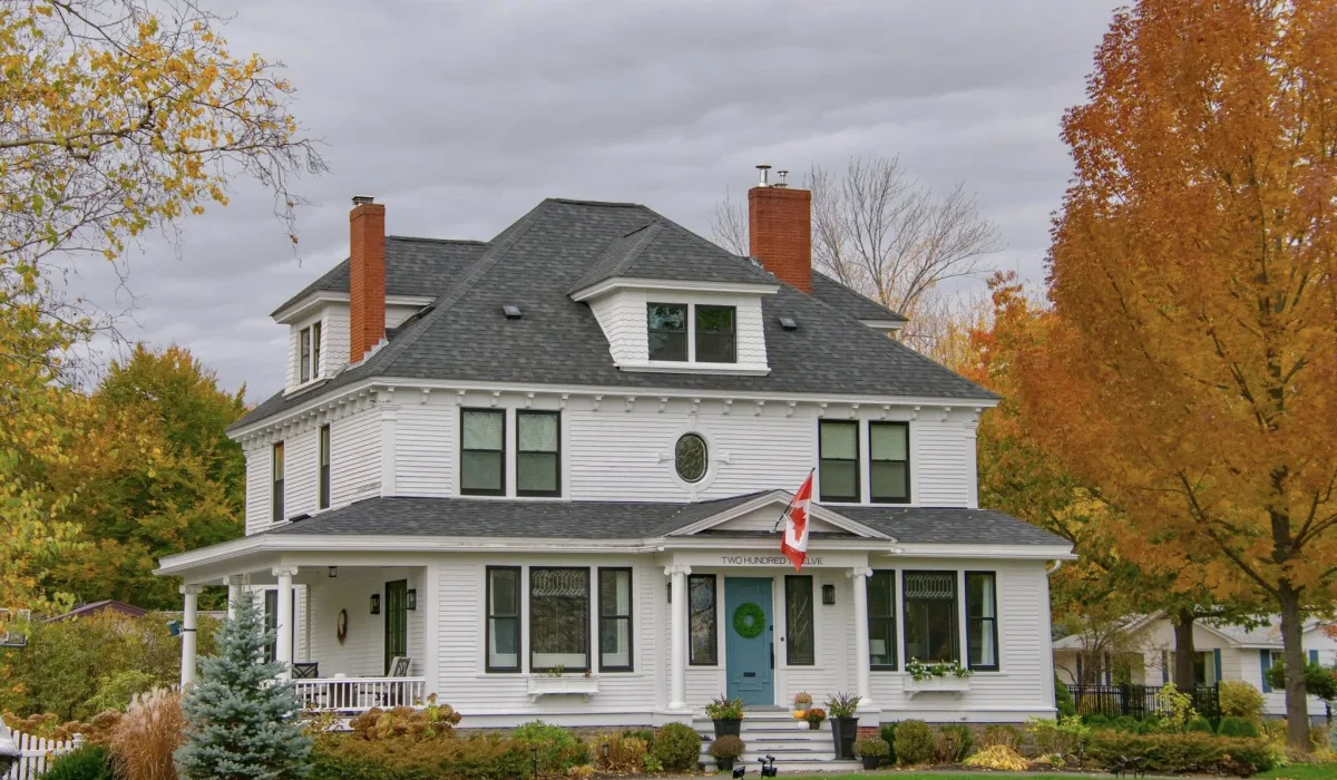 Large Fredericton-area home exterior in autumn, representative of mixed-age housing stock first-time buyers evaluate