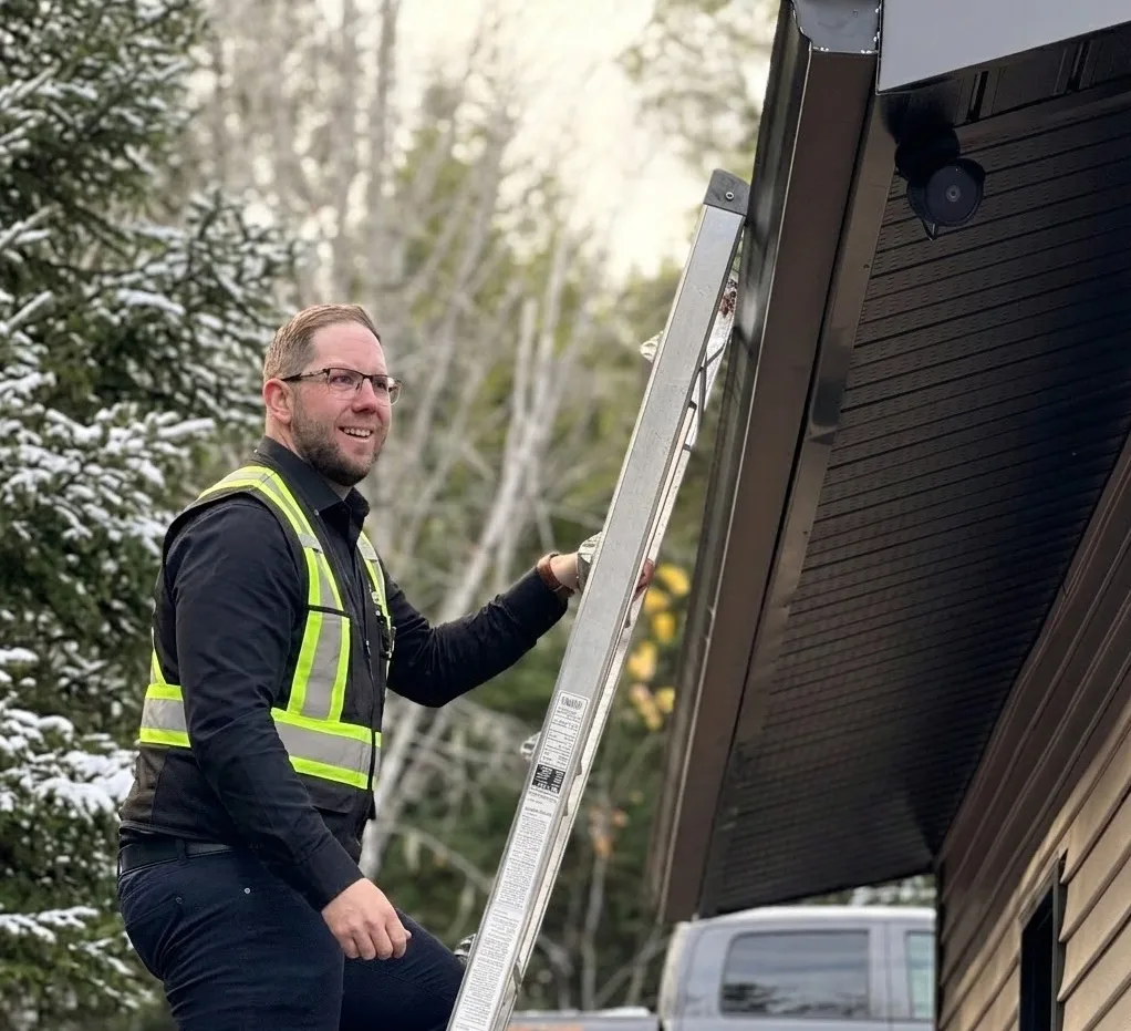 Professional home inspector performing a winter roofline check on site